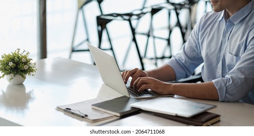 Smiling business man using laptop at office. Male hands typing on the notebook keyboard.Concept of young people work mobile devices - Powered by Shutterstock