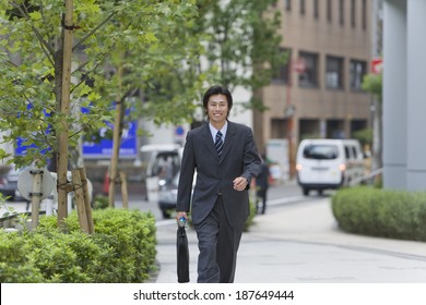 Smiling Business Man Walking On Sidewalk