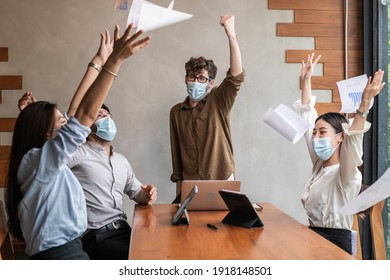 Smiling Business People Group,teamwork Of Young Asian,caucasian Throwing Papers, Documents, Wearing Face Mask Having Fun, Happy In Office, Workplace After Project Is Done. Celebrating Success Concept.