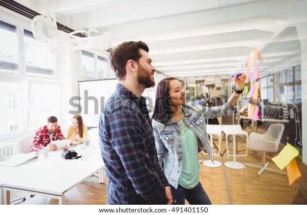 Smiling Business People Looking Sticky Notes Stockfoto