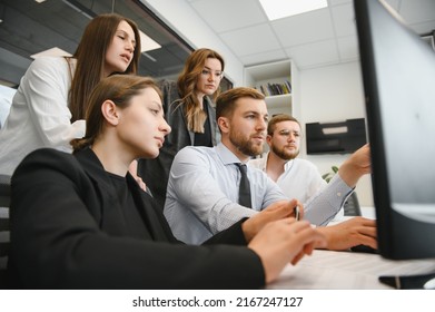 Smiling Business People Sitting At A Desk In Front Of A Laptop Computer.