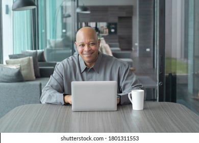 Smiling Business Senior Old Elderly Black American Man, African Person Working From Home On Table With Computer Notebook Laptop In Quarantine In Corona Virus Pandemic Concept.