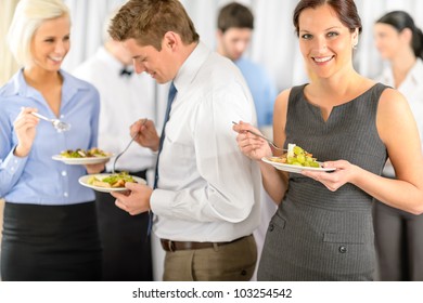 Smiling business woman during company lunch buffet hold salad plate