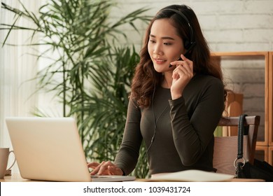 Smiling business woman in headset consuting clients
