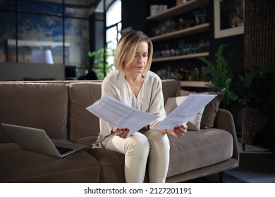 Smiling Business Woman Sit On Couch Watching Webinar On Laptop. Happy Middle Aged Woman Study On Online Distant Course