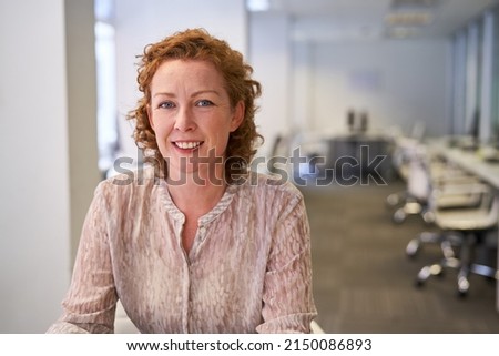Smiling business woman as a start-up founder or managing director in an open-plan office