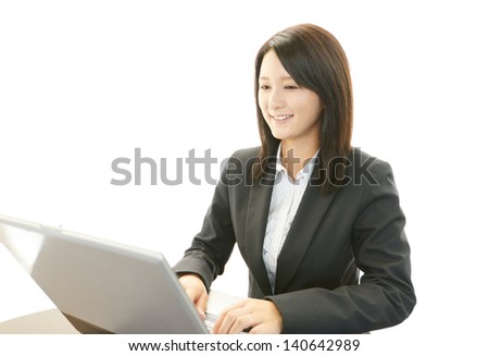 Smiling business woman using laptop