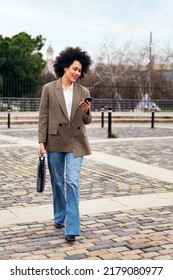 Smiling Business Woman Walks Using A Smart Phone