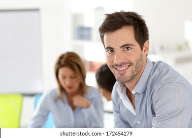 Smiling businessman attending work meeting - Powered by Shutterstock