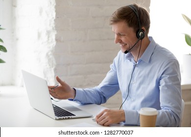 Smiling Businessman In Headphones Looking At Laptop Screen, Watching Good Webinar, Consulting Client, Distance Learning Languages, Making Notes, Happy Man Participating Online Conference