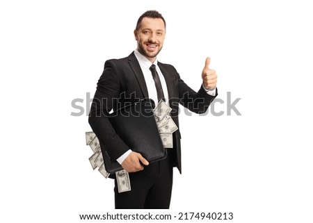 Smiling businessman holding a suitcase full of money and gesturing thumbs up isolated on white background