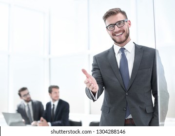 smiling businessman reaching out for a handshake - Powered by Shutterstock