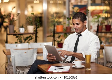 Smiling Businessman In The Restaurant  Working On Ipad