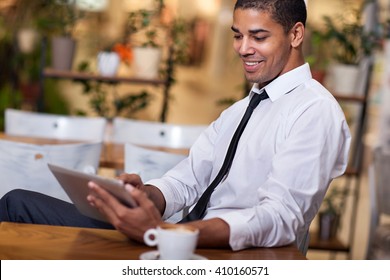 Smiling Businessman In The Restaurant  Working On Ipad