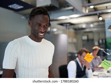 Smiling Businessman Standing By Reminder Notes On Glass Shield At Creative Office During Coronavirus