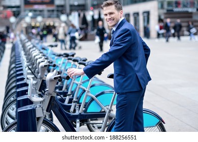 Smiling Businessman Take His Bicycle From Parking