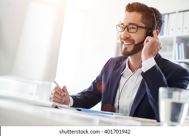 Smiling Businessman Using Headset When Talking To Customer