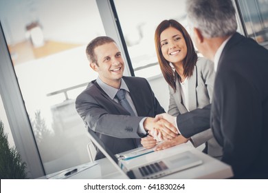 Smiling Businessmen Shaking Hands After Closing A Deal.