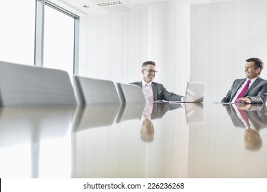 Smiling Businessmen Talking In Conference Room