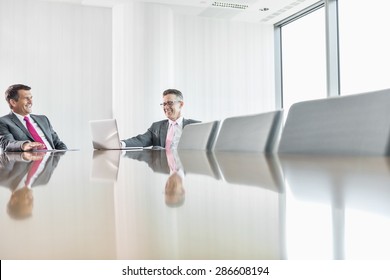 Smiling Businessmen Talking In Conference Room