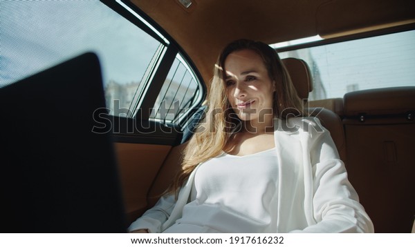 Smiling
businesswoman getting good news on laptop computer in modern car.
Happy business woman working on laptop in luxury car. Excited
female ceo reading project in business
car.