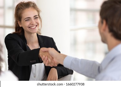 Smiling Businesswoman Handshaking Businessman At Meeting Negotiation. Happy Woman Hr Manager Accepts New Worker Candidate, Female Employer Shaking Hand Welcoming Hire Partner. Great First Impression