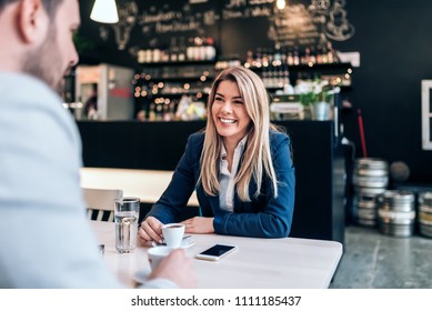 Smiling businesswoman having a cup of coffee with a collegue. - Powered by Shutterstock