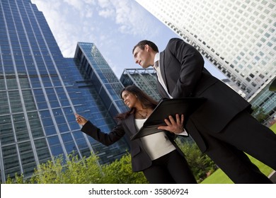 A Smiling Businesswoman And Her Male Colleague Taking Part In A Happy Business Meeting Outside In A Modern City Environment