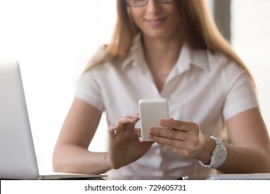 Smiling Businesswoman Holding New White Smartphone, Focus On Female Hands With Phone, Happy Lady Using Mobile App At Home Office Desk, Texting Message, Dialing Number On Corporate Cell, Close Up View