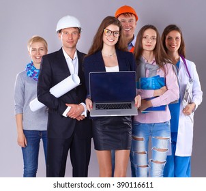 Smiling businesswoman with laptop  and group of industrial workers