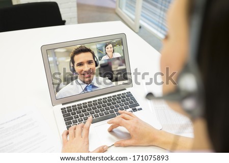 Smiling Businesswoman in the office on video conference, headset, Skype