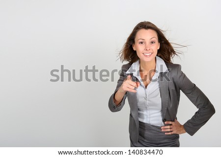 Smiling businesswoman pointing finger to camera