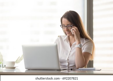 Smiling Businesswoman Talking On Phone While Using Laptop At Workplace, Manager Calling Client To Make Appointment, Arranging Meeting By Telephone Conversation, Consulting Customer About Online Order