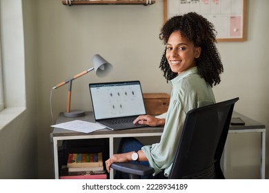 Smiling businesswoman working on a laptop in her home office - Shutterstock ID 2228934189