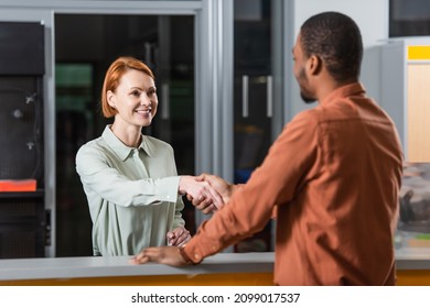 Smiling Car Dealer Shaking Hands With Blurred African American Customer