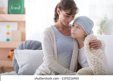 Smiling Caregiver Supporting Sick Child With Cancer Wearing Blue Headscarf