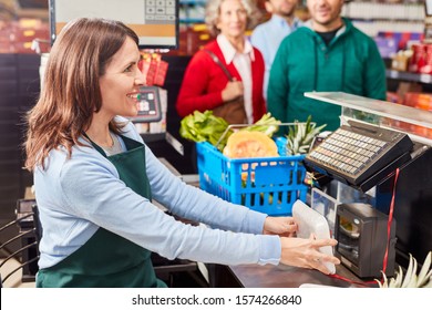 Smiling Cashier At The Supermarket Cashier Uses Barcode Scanner