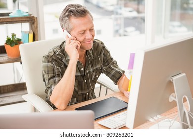 Smiling Casual Businessman Having A Phone Call In The Office