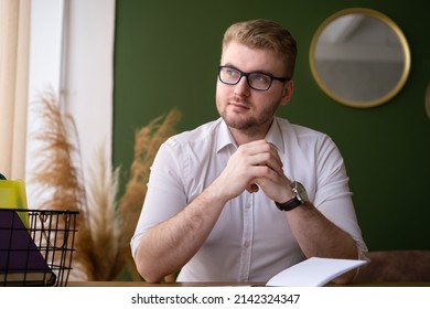 Smiling Caucasian Blond Adult Man Working,sitting At Desk Indoors In Stylish Modern Home Interior.Serious Thoughtful Businessman At Work.