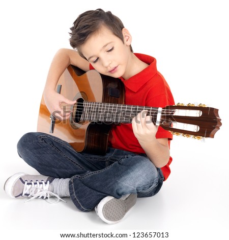 Smiling caucasian boy is playing the acoustic guitar - isolated on white background