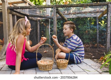 Smiling caucasian brother and sister collecting eggs from hen house in garden. self sufficiency and spending time at home. - Powered by Shutterstock