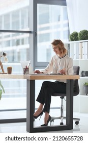 Smiling caucasian businesswoman watching on laptop and writing with pencil during work at office. Concept of modern successful woman. Business and entrepreneur lifestyle. Young woman sitting at table - Shutterstock ID 2120655728