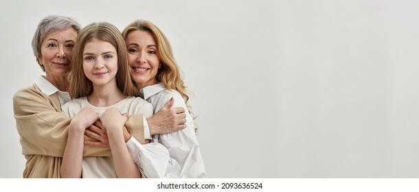 Smiling caucasian family of three female generations hugging and looking at camera. Age and generation concept. Family relationship and closeness. Isolated on white background Studio shoot. Copy space - Shutterstock ID 2093636524