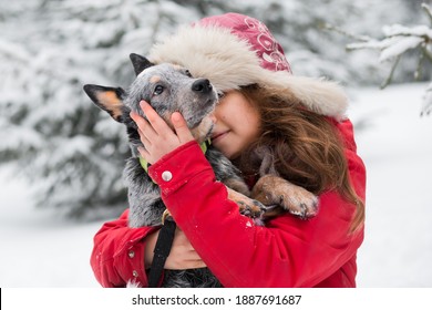 Smiling Caucasian Girl Embracing Blue Healer Puppy In Winter.