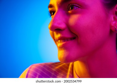 Smiling. Caucasian Happy Young Woman's Portrait On Dark Studio Background In Neon Light. Female Model In Casual Style. Concept Of Human Emotions, Facial Expression, Youth, Sales. Copy Space For Ad.