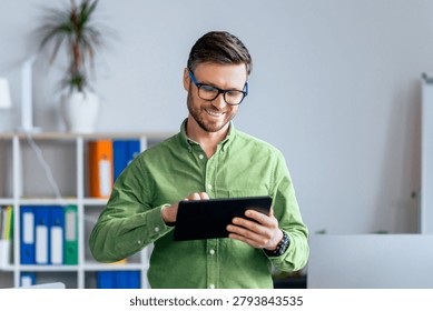 Smiling Caucasian Man Using Tablet In Modern Office, Business Concept