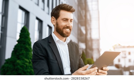 Smiling Caucasian Man Using Tablet Outdoors In Urban Setting, Business Concept