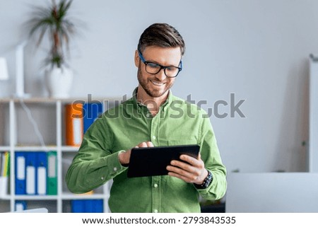 Smiling Caucasian Man Using Tablet In Modern Office, Business Concept