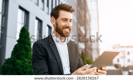 Smiling Caucasian Man Using Tablet Outdoors In Urban Setting, Business Concept