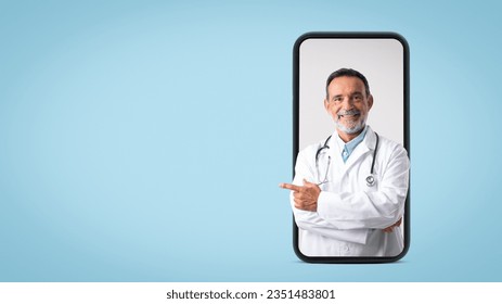 Smiling caucasian senior doctor therapist in white coat point finger on free space on big phone screen, isolated on blue background, studio. Professional advice, medical care, health care - Powered by Shutterstock